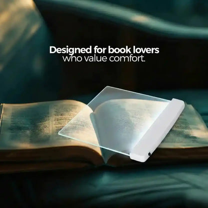 VisionGlow transparent flat reading light panel on open book designed for book lovers who value comfort — teal dark atmospheric background