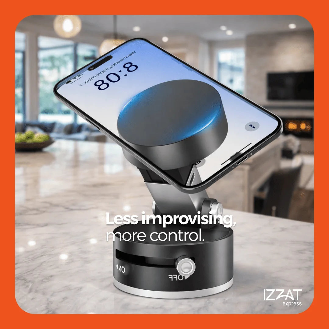 Tazzi MagnaFold Phone Mount displayed on a marble kitchen counter in an upscale home interior — the phone rests at a perfect tilt angle with text overlay 'Less improvising, more control' and IZZAT Express branding on orange border